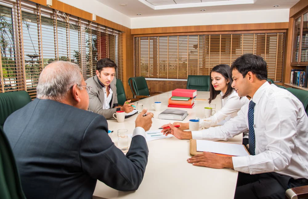 Business strategy meeting with four professionals around a conference table