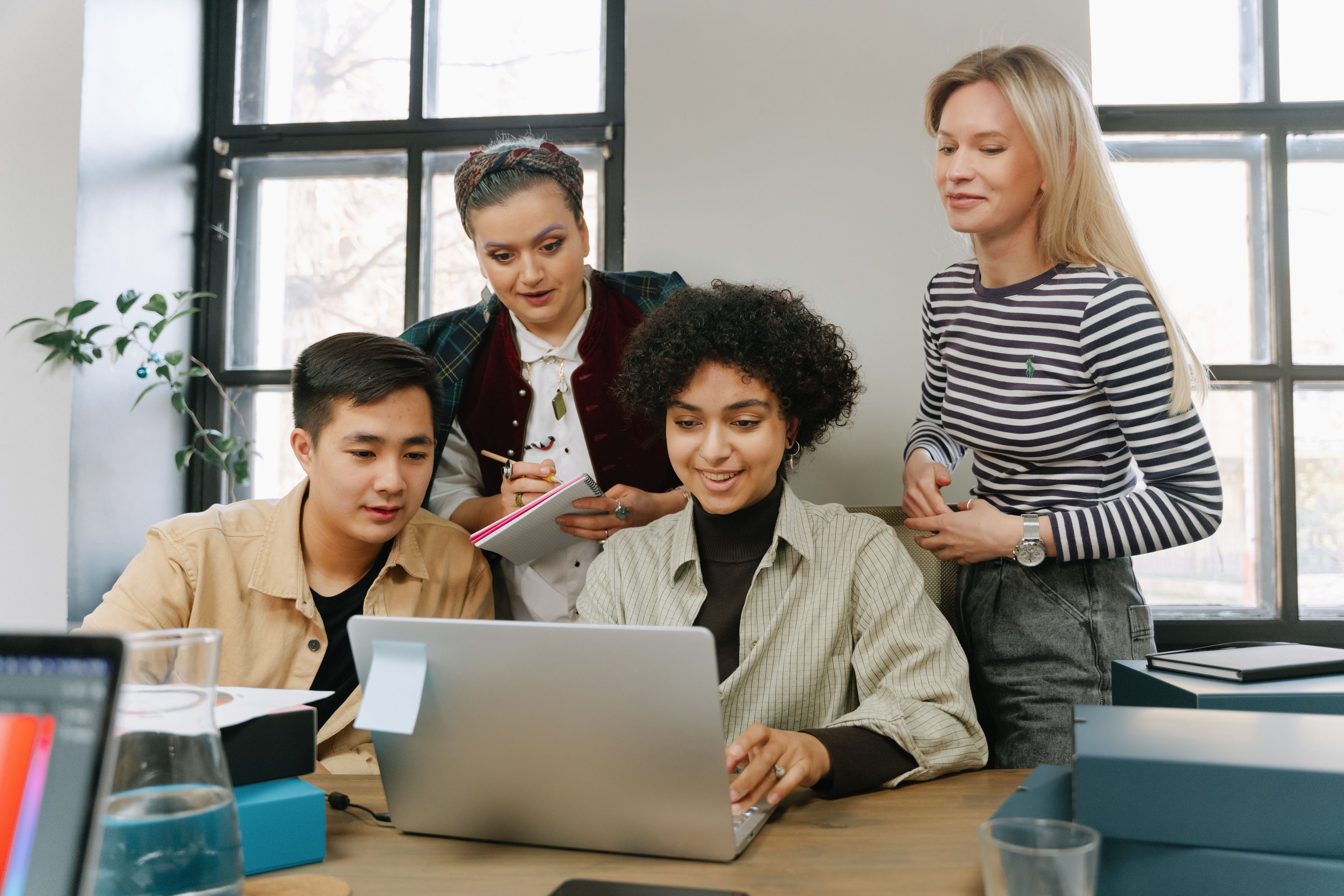 Group of students and mentor looking at a laptop
